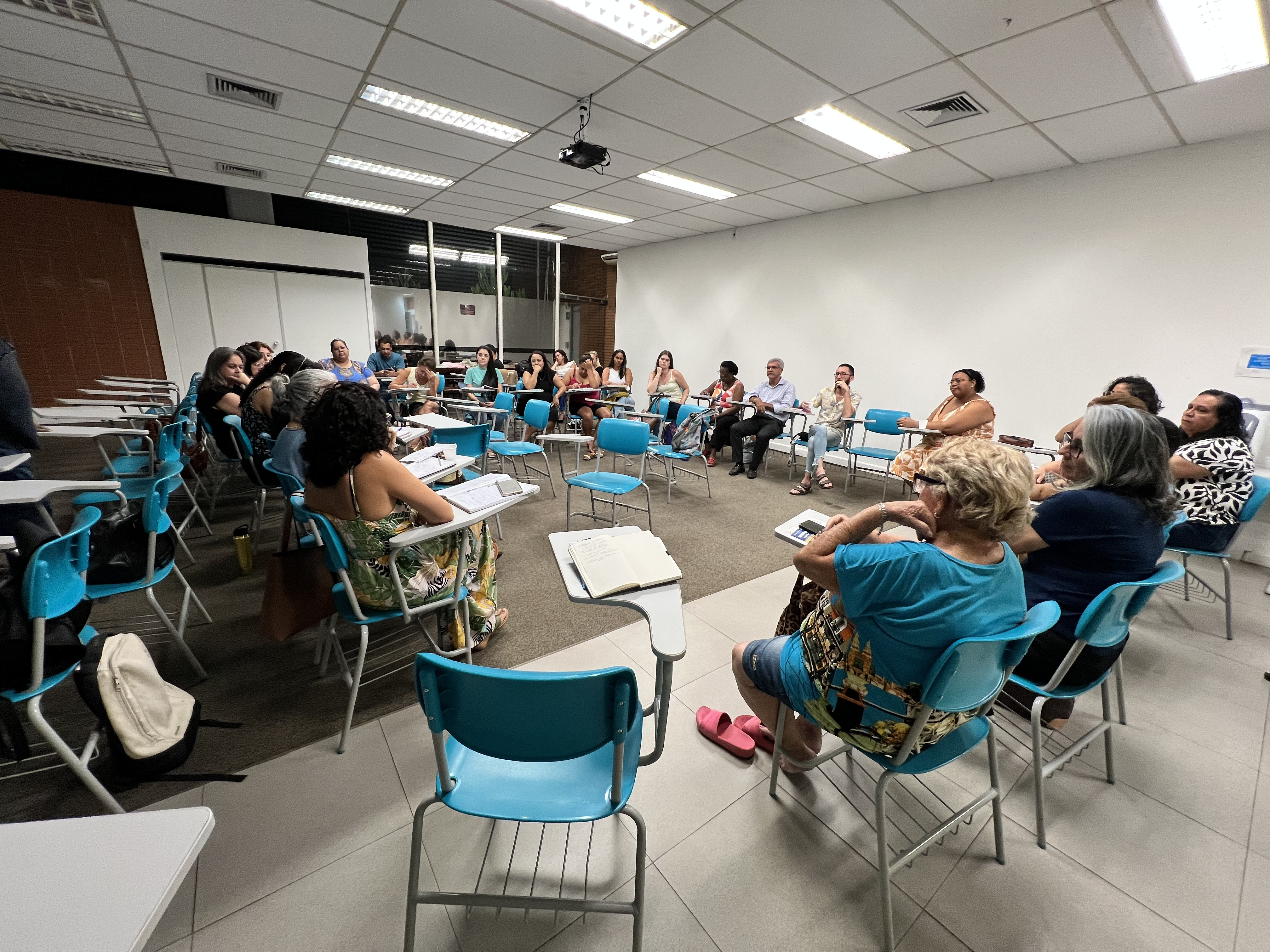 31/01/2025 - Aula do curso piloto do EnvelheCiência, no MOVA, na cidade de São Carlos. Aula proferida pela professora Márcia Cominetti e professora Lea Veras, com apoio técnico das gerontólogas Karen Pulgatti e Letícia Palma. Na imagem vemos os professores sentados em uma grande roda, em discussão sobre a temática proposta na aula.